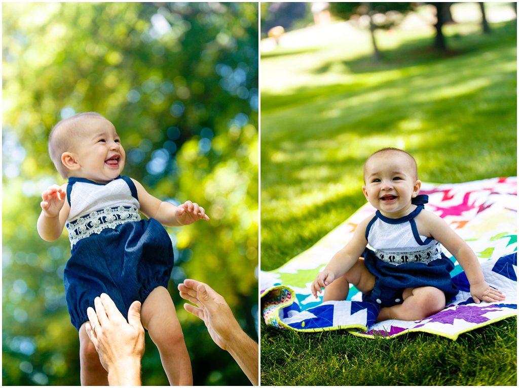 Baby giggles and laughs in handmade white and navy romper sitting on handmade colorful quilt by Ristaino Photography of Sarasota FL