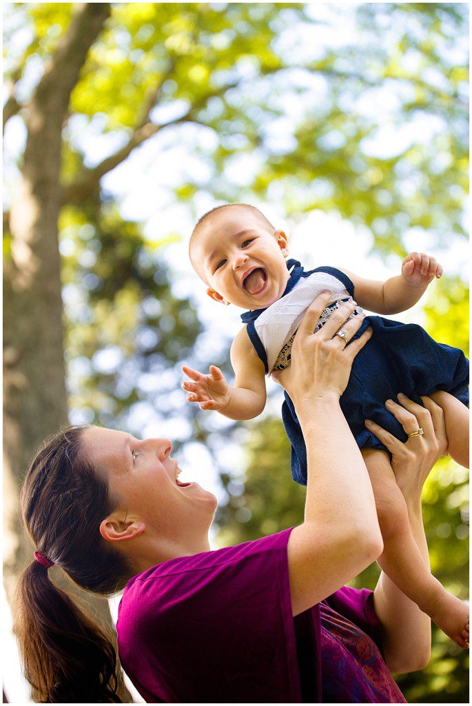 Woman in purple top holds giggling baby in air during Beauty Revived Session by Ristaino Photography of Sarasota FL