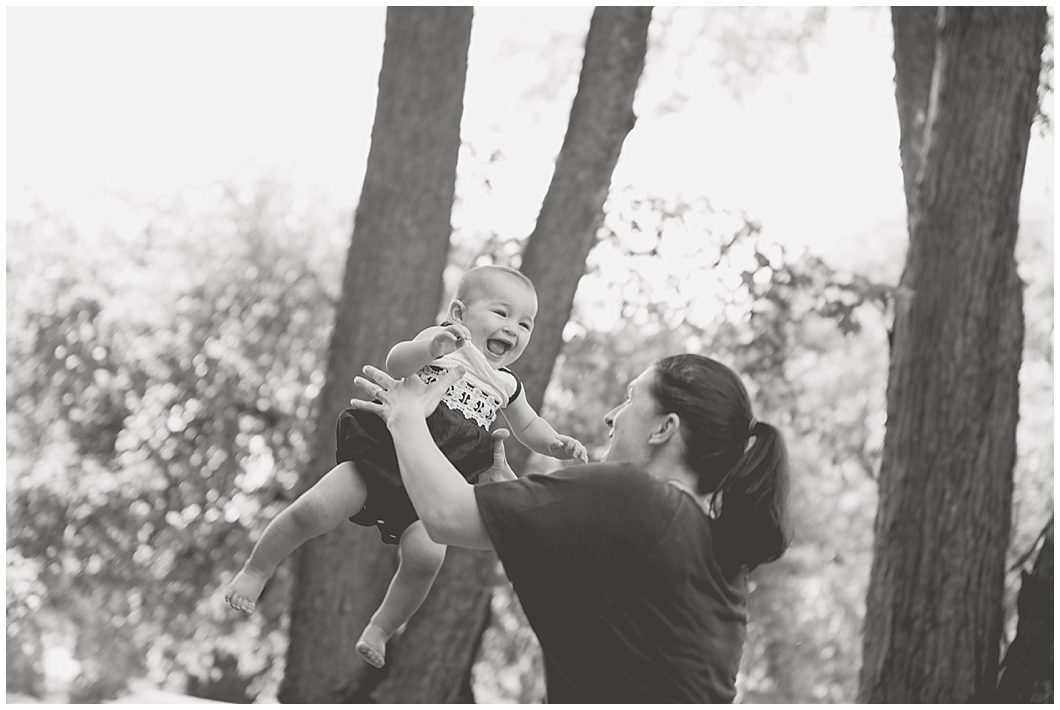 Woman tosses giggling baby in the air at this Beauty Revived session by Ristaino Photography of Sarasota FL