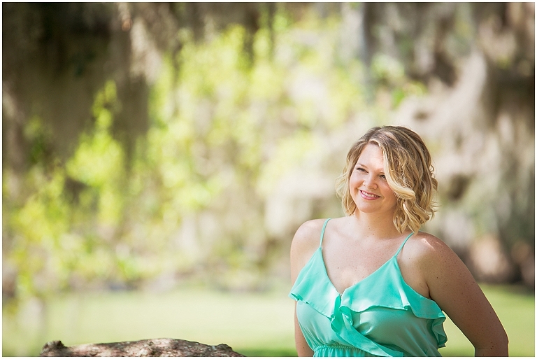 Young woman in seafoam green sundress under a huge oak tree with spanish moss in this image of Sarasota Portrait Photography by Ristaino Photography