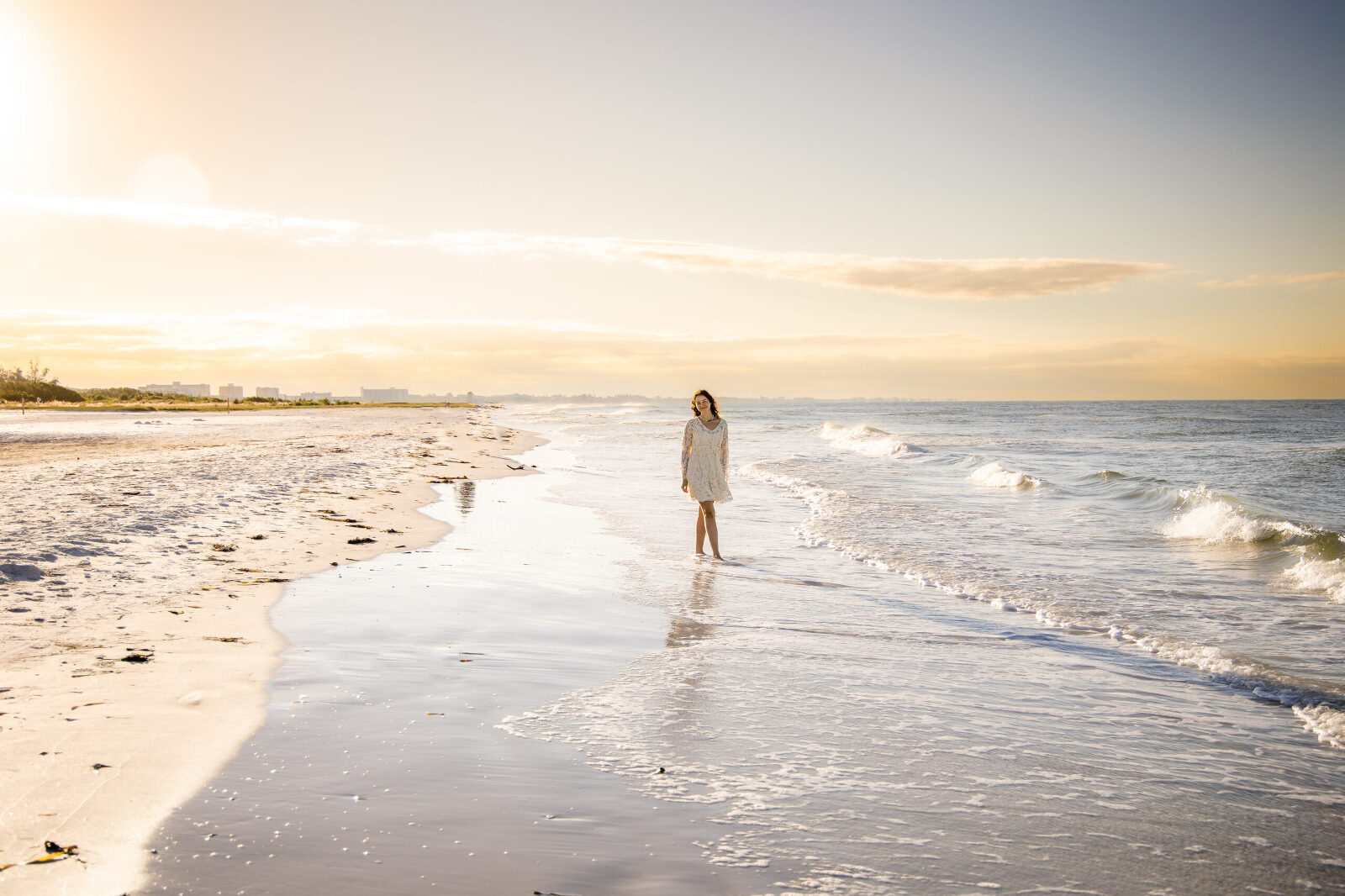 teen girl in white dress on siesta key beach at sunrise