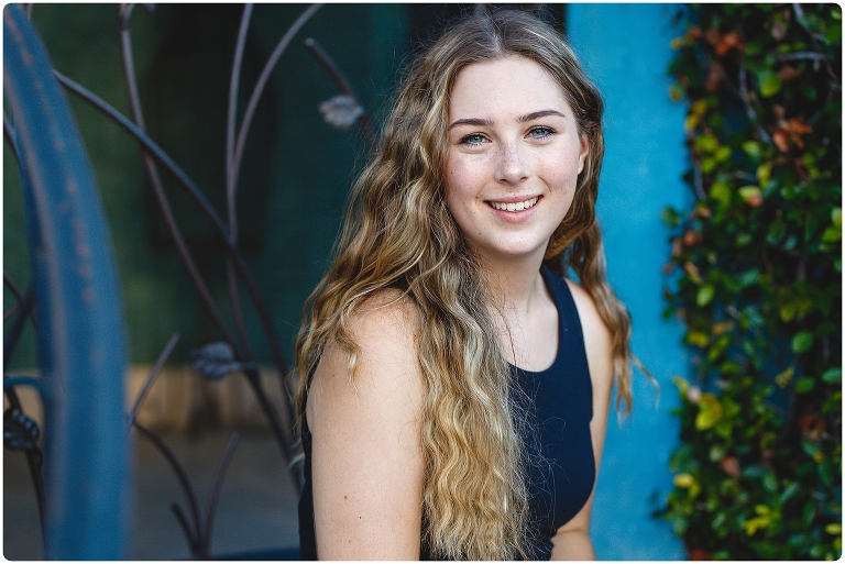 Burns Court Senior Portraits girl in front of blue wall and iron gate-by-Michaela-Ristaino-Photography_0008.jpg