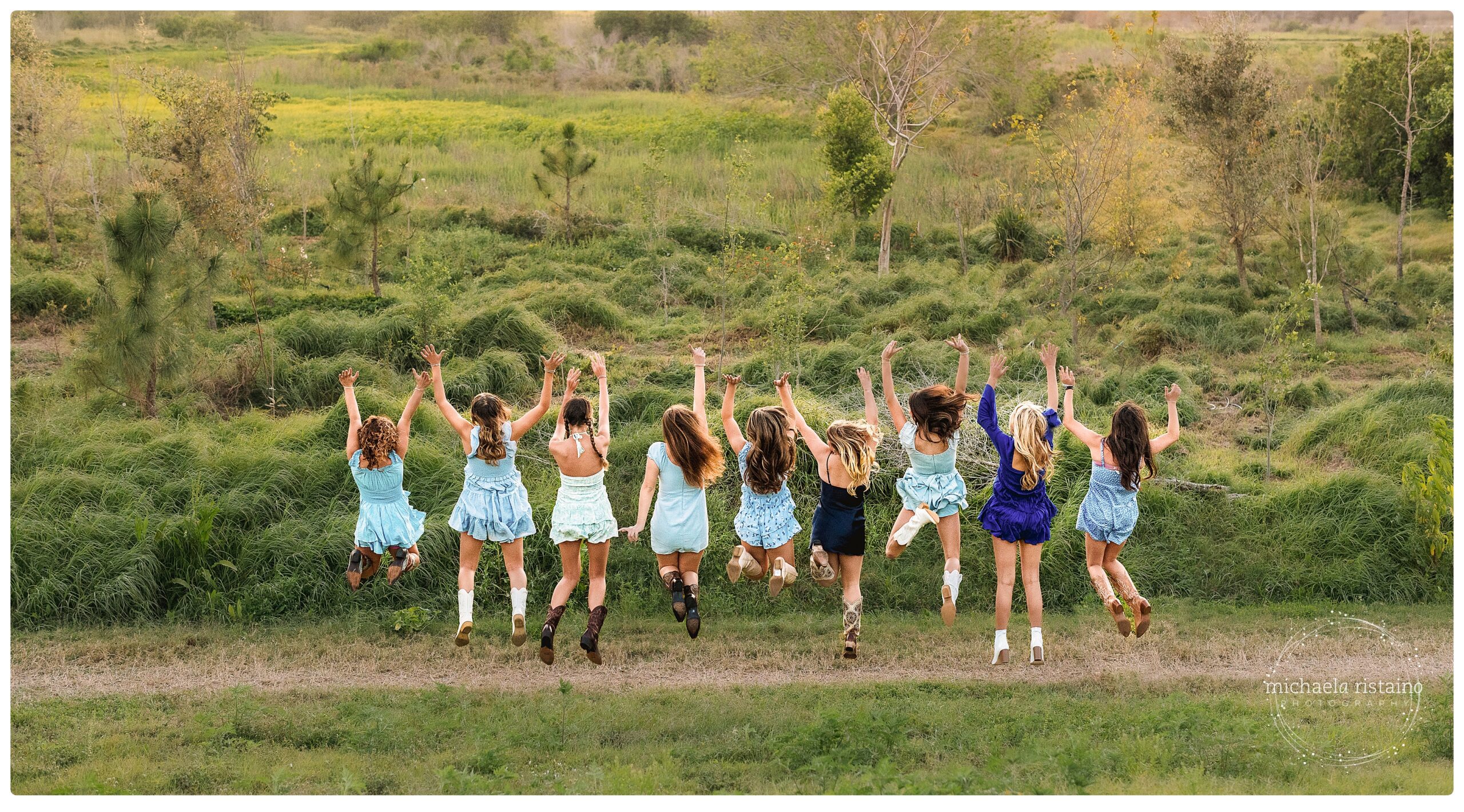 Sweet 16 girls jumping at Celery Fields in Sarasota wearing blue rompers and cowboy boots