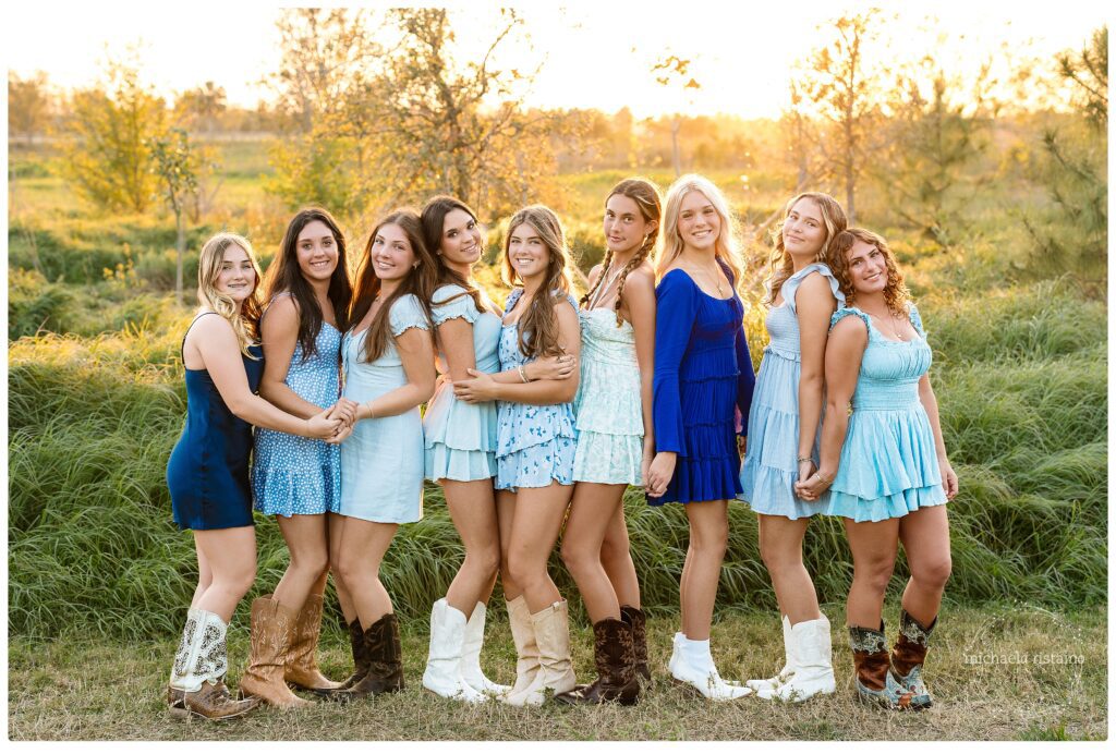 Sweet 16 girls laughing together at Celery Fields in Sarasota wearing blue rompers and cowboy boots