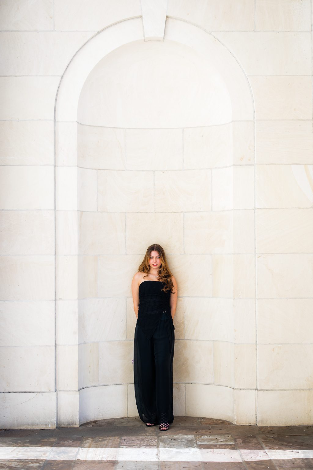 Senior portrait at the Federal Courthouse in downtown Sarasota Florida, girl in black outfit standing in stone archway, Michaela Ristaino Photography