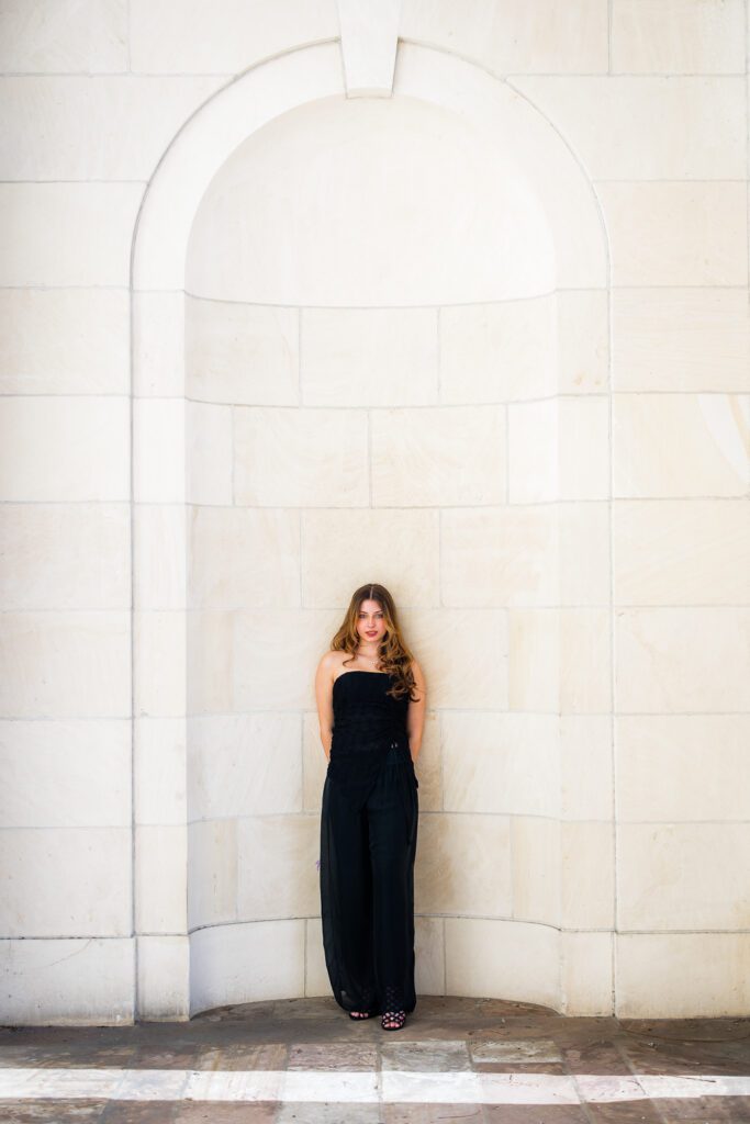 Editorial senior portrait against architectural stone archway, Sarasota