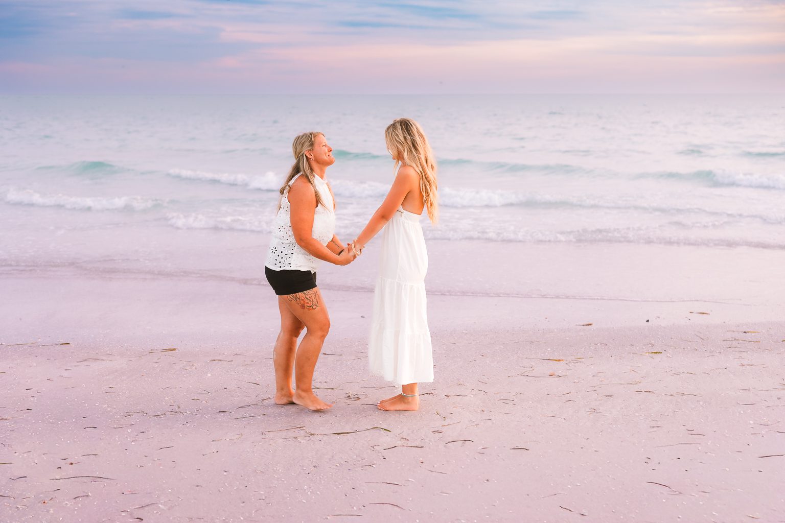 Mother and senior daughter sharing a quiet moment on Sarasota beach, authentic and joyful