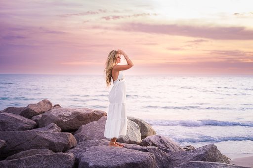 Senior portrait on rocky Sarasota coastline at sunset
