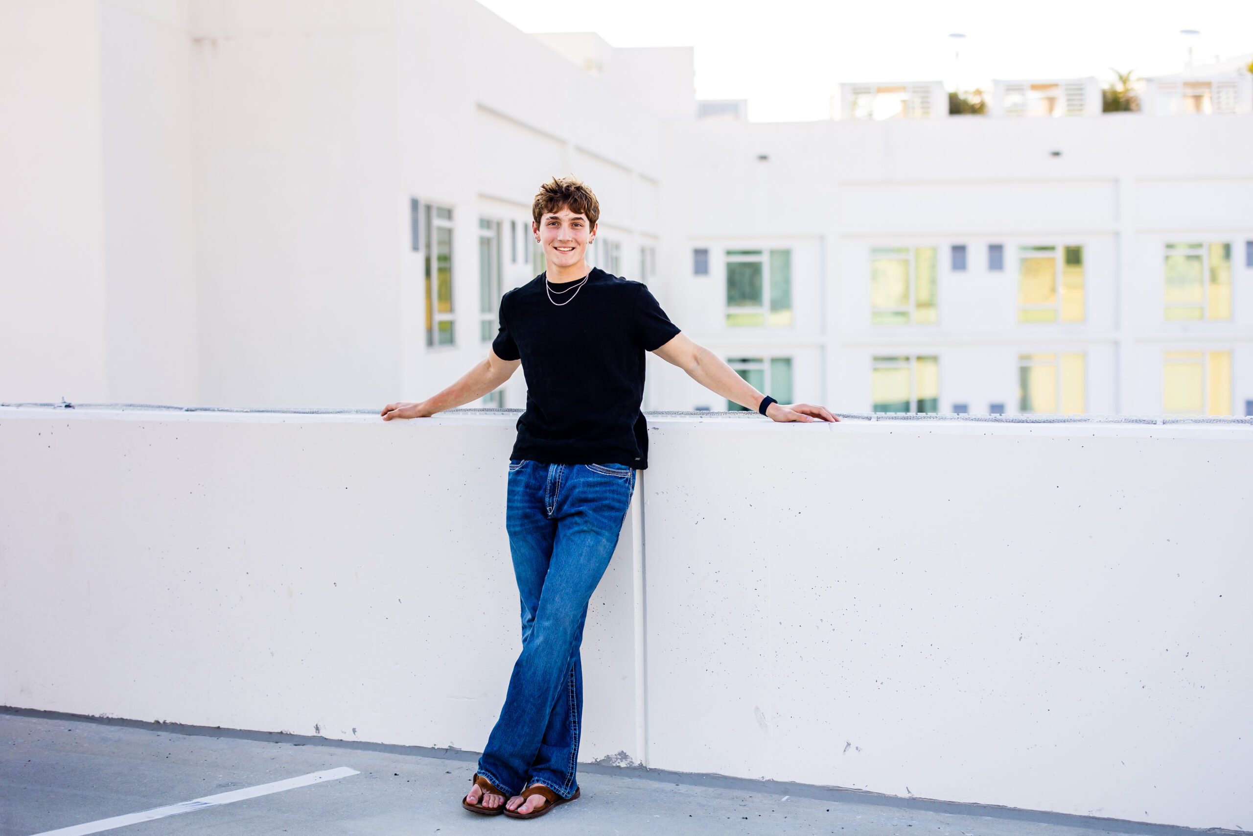 Senior guy portrait on rooftop in downtown Sarasota, casual black top and jeans style