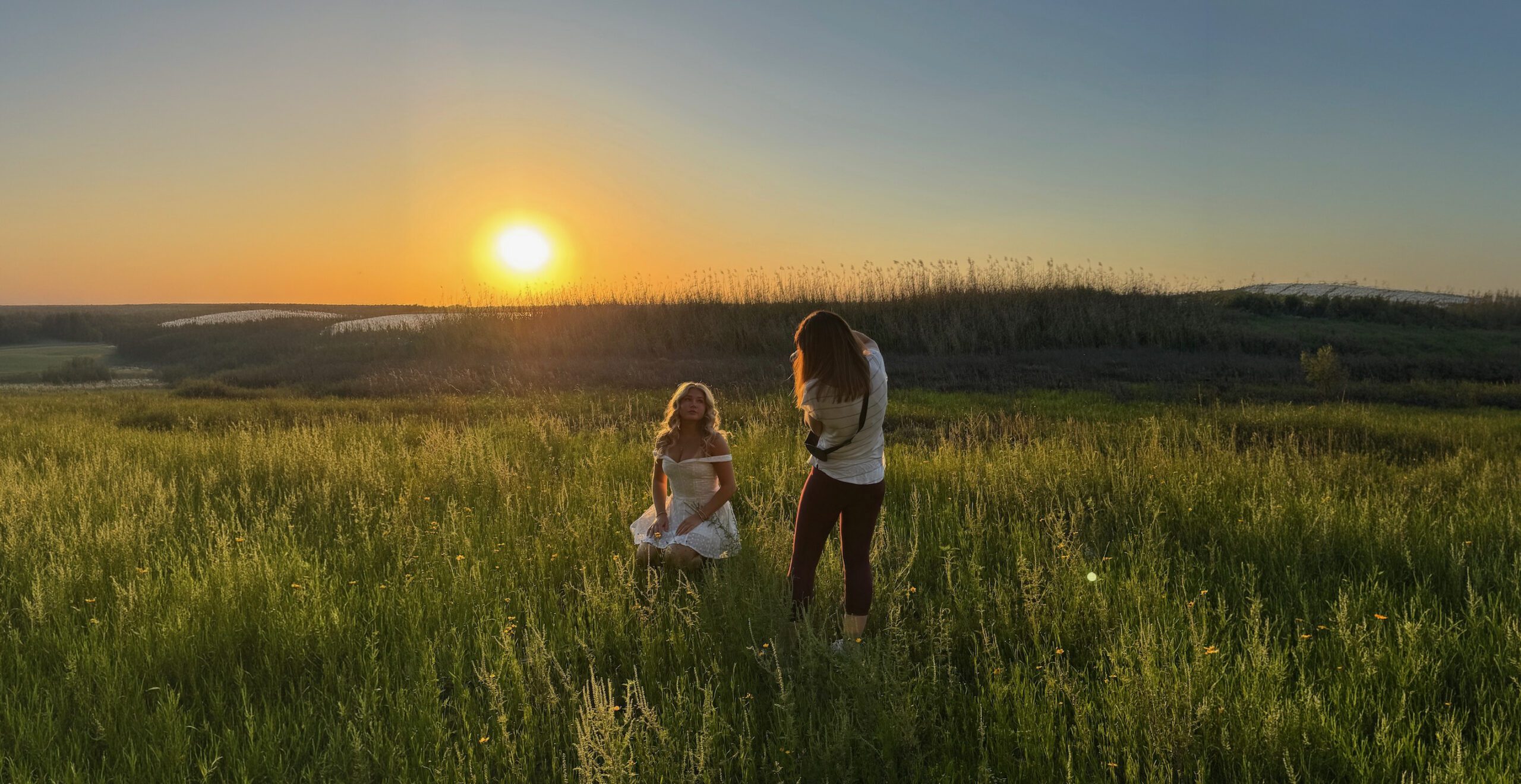 Michaela Ristaino photographing a senior portrait session at golden hour in a Sarasota field