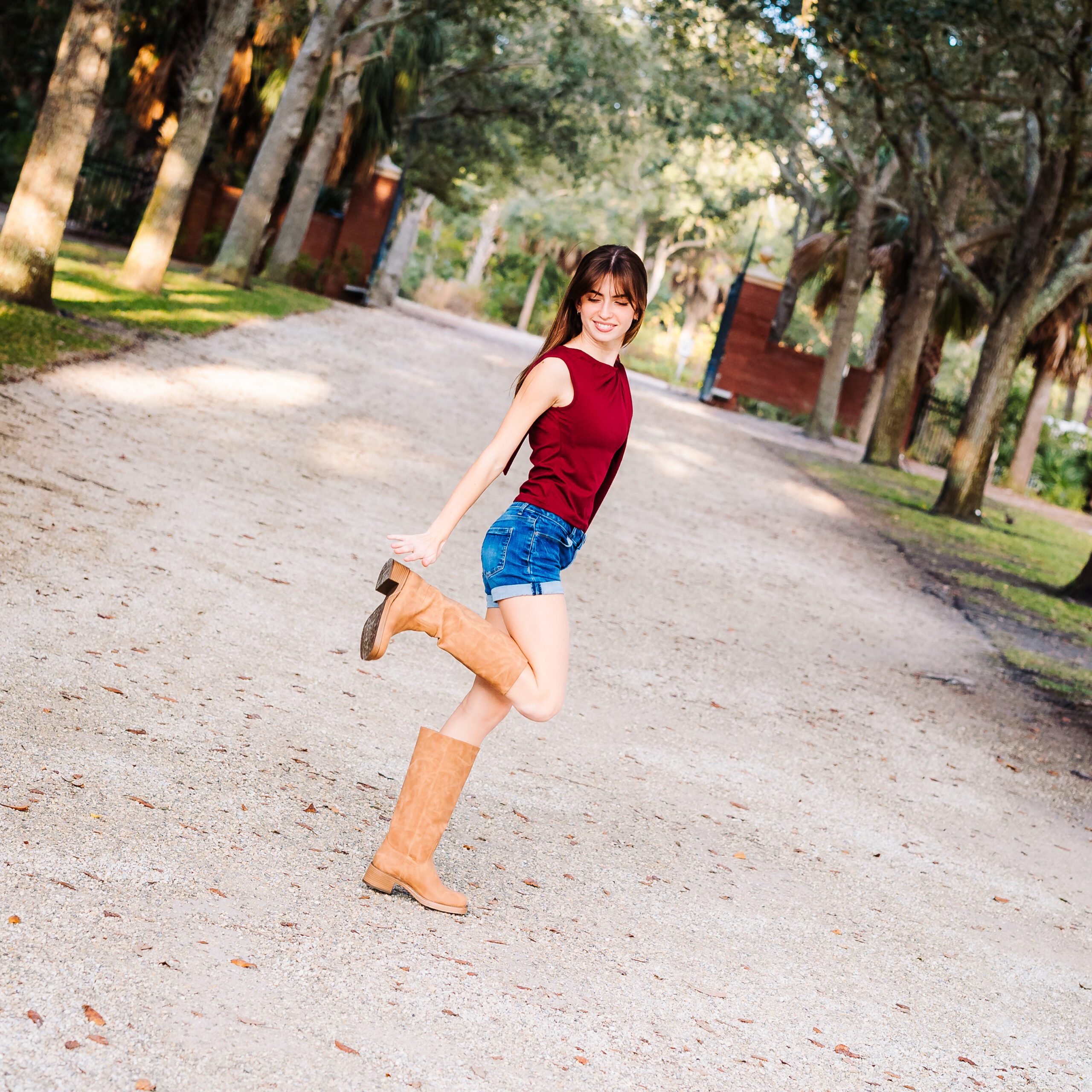 What to wear for senior photos: Sarasota senior girl in shorts, top, and boots outfit built for movement
